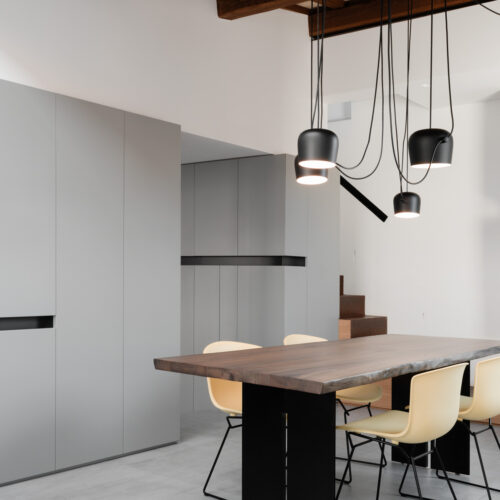 1 B0037187 sala da pranzo con soffitto in legno a vista ed arredo su misura sospesa flos aim