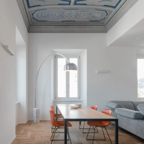 2 B0037298 soggiorno con affresco blu parquet tavolo su misura sedie orange red knoll